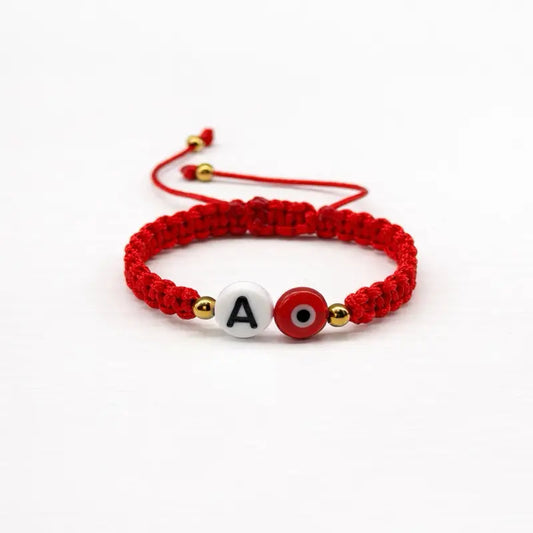 Adjustable red bracelet with evil eye and initials.